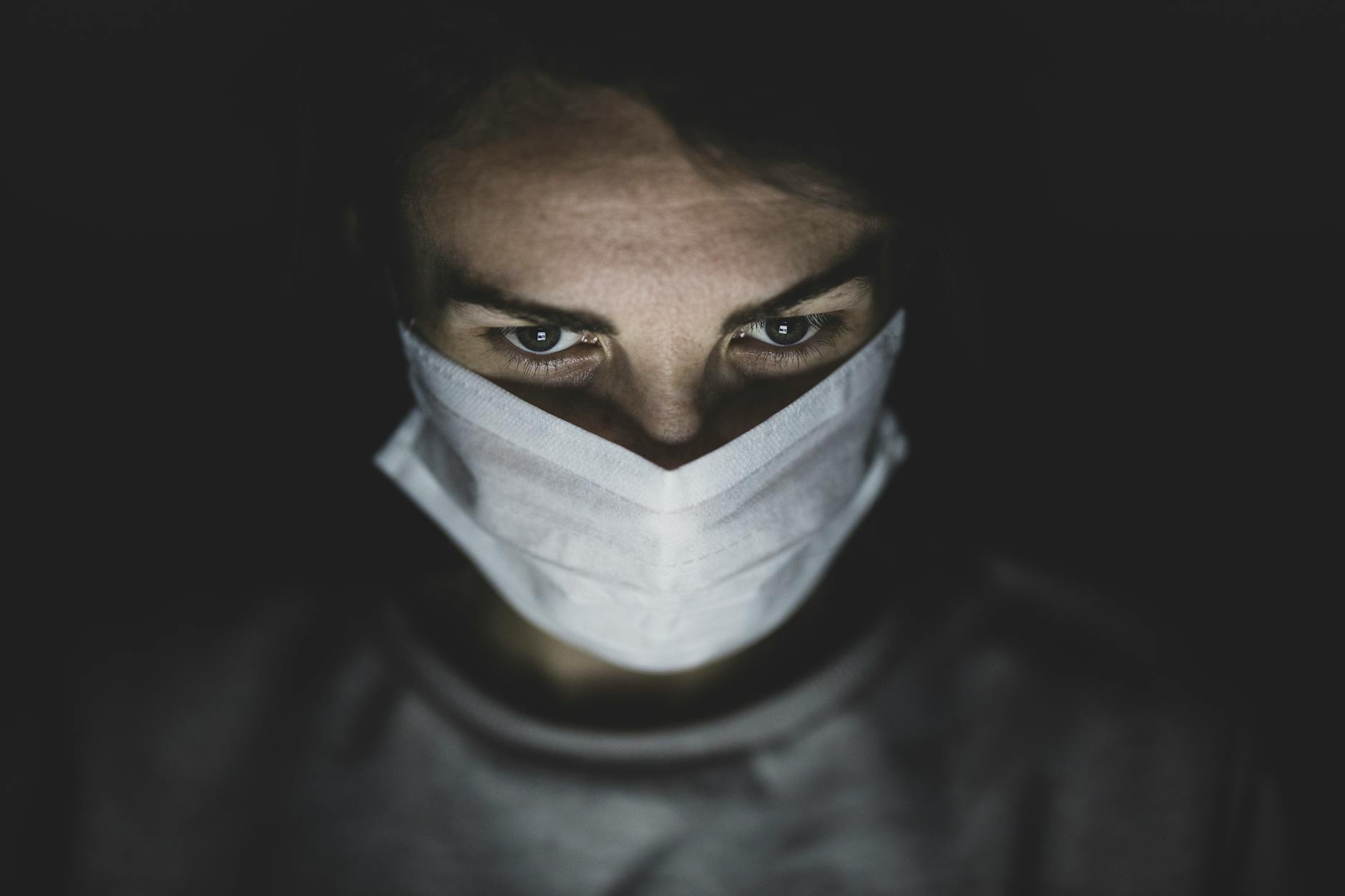 man wearing face mask in a dark room